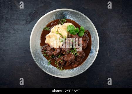 Tradizionale ragù di veleno brasato tedesco con verdure e tagliatelle in salsa dolce e piccante al cioccolato al vino rosso servito come vista dall'alto in un nordico Foto Stock