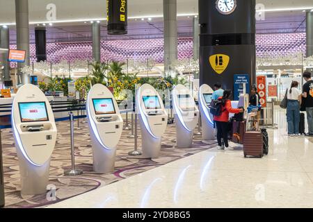 Check-in self-service, terminali elettronici nelle partenze dal Terminal 4 dell'Aeroporto Changi di Singapore Foto Stock