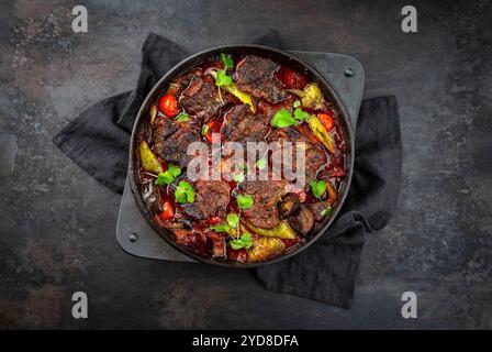 Stufato di agnello brasato greco tradizionale con verdure e olive in un'abbondante salsa di carne con vino rosso servito come vista dall'alto in un desi Foto Stock