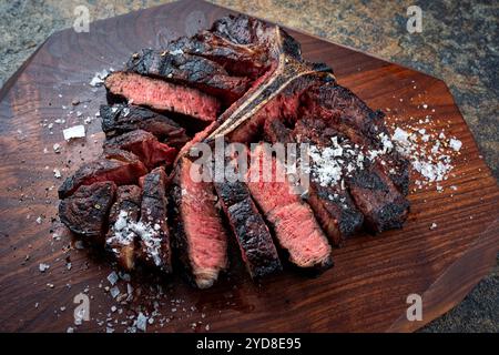 Barbecue tradizionale wagyu stagionato a secco bistecca alla fiorentina tagliata con sale e pepe servita da vicino Foto Stock