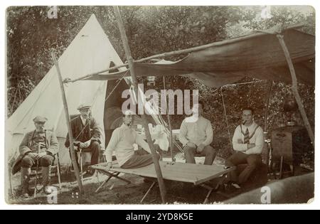 Cartolina dell'era post-WW1 di giovani e anziani in campeggio, fratello e sorella giovani, partita di cricket, Regno Unito circa 1918, 1919 PC stampbox mezzo pence Foto Stock