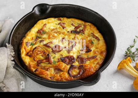 Colazione salutare, omelette con funghi della foresta fritti stagionali, galline in padella su sfondo chiaro Foto Stock