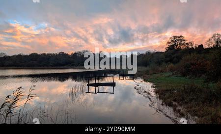 Splendido tramonto arancione sul lago, paesaggio a Ballyquirke lough, Galway, Irlanda, sfondo naturale Foto Stock