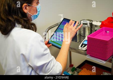 Analisi del sangue in laboratorio con il sistema LabPad, un analizzatore portatile progettato per eseguire test rapidi da un volume ridotto di campioni di sangue. Consultazione con LabPad 016837 091 Foto Stock