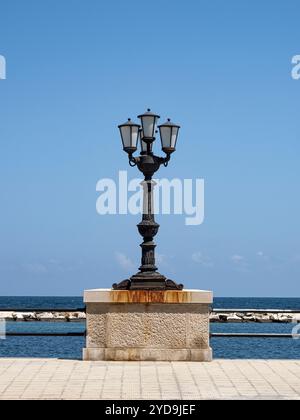 Lampada da strada singola sul lungomare. Vista sul mare, cielo azzurro, estate, vacanza. Foto Stock