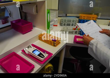 Analisi del sangue in laboratorio con il sistema LabPad, un analizzatore portatile progettato per eseguire test rapidi da un volume ridotto di campioni di sangue. Consultazione con LabPad 016837 028 Foto Stock