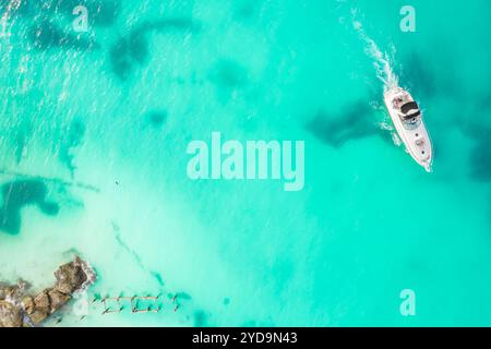 Splendida vista dall'alto dello yacht. Vista aerea della piccola nave galleggiante di lusso nel mare blu dei Caraibi. Yacht al mare a Cancun in Messico Foto Stock