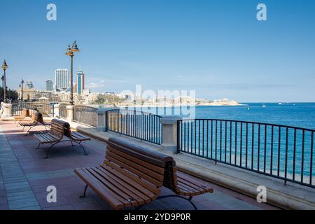 Passeggiata sul lungomare di Sliema e vista sulla città di San Giuliano, Malta Foto Stock