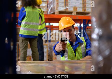 Gruppo di dipendenti in un magazzino ricambi auto, esaminare i ricambi auto pronti per essere spediti al fattore di assemblaggio automobilistico Foto Stock