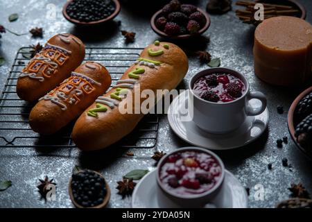 Guaguas de Pan con tazze di Colada Morada, cibo tradizionale ecuadoriano per il giorno dei morti, circondato dagli ingredienti per cucinare di nuovo la colada Foto Stock