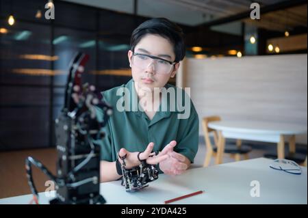 Il progresso della tecnologia ha contribuito ad alleviare gli oneri umani. Robot controllato a mano è un altro tipo di lavoro che assis Foto Stock