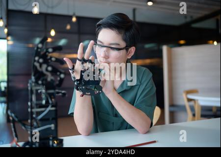 Il progresso della tecnologia ha contribuito ad alleviare gli oneri umani. Robot controllato a mano è un altro tipo di lavoro che assis Foto Stock