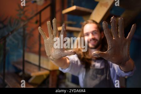 Artista di ceramica, Young, che crea un pezzo di argilla con calma e meticolosamente per produrre l'opera più attraente possibile Foto Stock