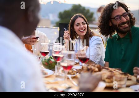 Giovane coppia caucasica sorridente seduto al tavolo presso un accogliente barbecue estivo all'aperto Foto Stock