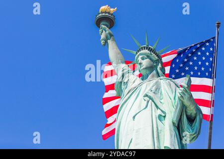 Statua della libertà con una grande bandiera americana e skyline di New York sullo sfondo Foto Stock