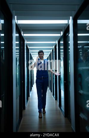 Uomo d'affari nel corridoio della sala conferenze, che parla con un assistente al telefono per chiedere qualche dettaglio. Foto Stock