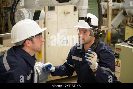 I due ingegneri controllano il funzionamento dei robot di saldatura. Foto Stock