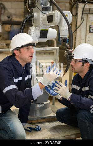 I due ingegneri controllano il funzionamento dei robot di saldatura. Foto Stock
