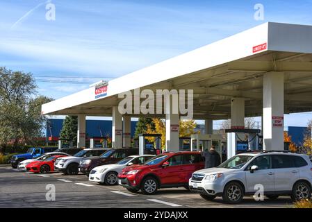 25 ottobre 2024: Una linea di auto che si riempie presso il distributore di benzina Costco Wholesale, che offre sconti sulla benzina a persone con abbonamenti a pagamento. Severa Foto Stock