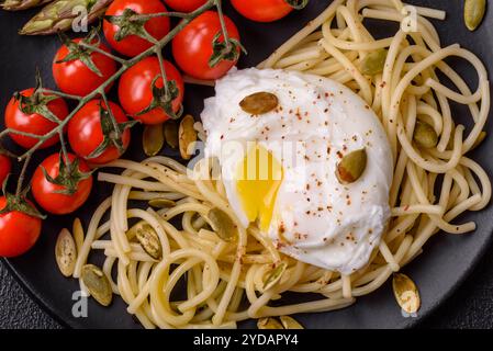 Colazione deliziosa e abbondante, con uova in camicia su pane tostato con formaggio spalmabile e asparagi Foto Stock