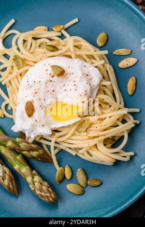 Colazione deliziosa e abbondante, con uova in camicia su pane tostato con formaggio spalmabile e asparagi Foto Stock