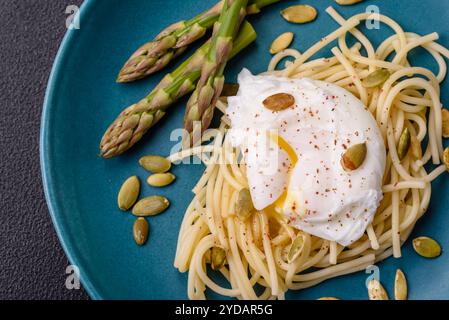 Colazione deliziosa e abbondante, con uova in camicia su pane tostato con formaggio spalmabile e asparagi Foto Stock