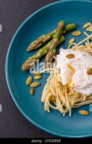 Colazione deliziosa e abbondante, con uova in camicia su pane tostato con formaggio spalmabile e asparagi Foto Stock