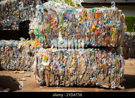 I vecchi flaconi di plastica utilizzati vengono compressi e raggruppati insieme per prepararli al riciclaggio. Foto Stock