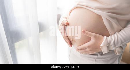 Donna incinta tiene le mani sulla pancia toccando il suo bambino curando la sua salute bella felice incinta womanÂ tenero umore foto Foto Stock