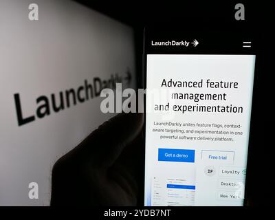25 ottobre 2024: Stoccarda, Germania - 06-12-2024: Persona che detiene il cellulare con pagina web della società di software statunitense Catamorphic Co. (LaunchDarkly) davanti al logo. Messa a fuoco al centro del display del telefono. (Credit Image: © SOPA Images via ZUMA Press Wire) SOLO PER USO EDITORIALE! Non per USO commerciale! Foto Stock