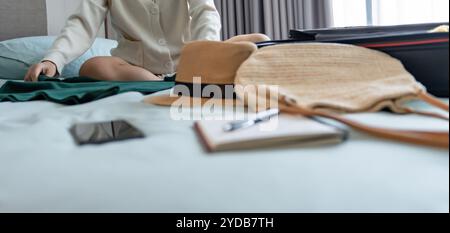 Donna che trasporta la valigia sul letto per una nuova lista di viaggio per pianificare il viaggio preparando la vacanza Prenota ora viaggio trasporto Foto Stock