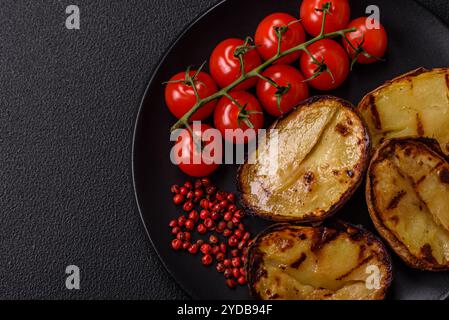 Deliziose metà di patate in bucce cotte alla griglia con sale, spezie ed erbe aromatiche Foto Stock