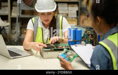 Due lavoratrici di magazzino che contano gli articoli in un magazzino industriale al piano rialzato della fabbrica. che è uno spazio di archiviazione per s. Foto Stock