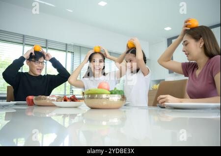 Famiglia asiatica stanno facendo colazione insieme felicemente nella sala da pranzo della casa. Foto Stock