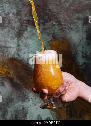 Versare birra fresca nel bicchiere Foto Stock