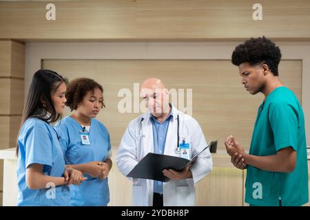 Un professore di medicina fornisce consigli sugli esami dei pazienti agli studenti di medicina che praticano Foto Stock