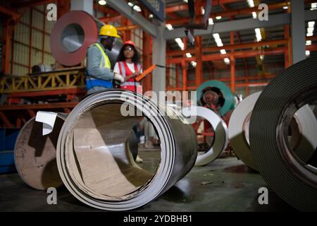 Due tecnici che ispezionano e testano il funzionamento delle gru di sollevamento in impianti industriali pesanti. Foto Stock