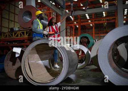 Due tecnici che ispezionano e testano il funzionamento delle gru di sollevamento in impianti industriali pesanti. Foto Stock