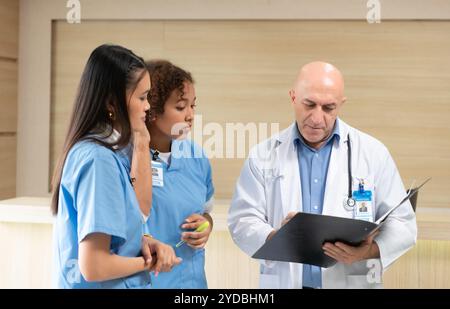 Un professore di medicina fornisce consigli sugli esami dei pazienti agli studenti di medicina che praticano Foto Stock