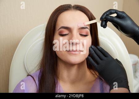 Bella ragazza ottenere ceretta di fronte in salone di bellezza Foto Stock