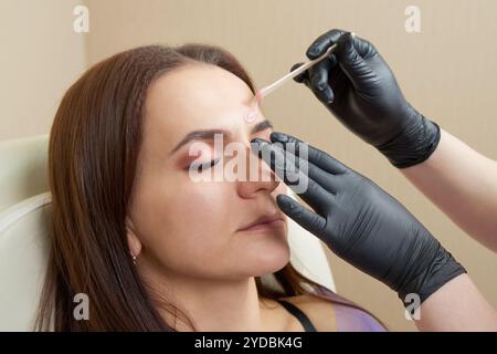 Bella ragazza che si fa scopare le sopracciglia nel salone di bellezza Foto Stock