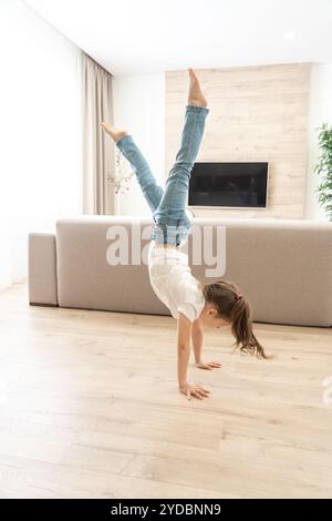 Ragazza che cammina capovolta sulle braccia a casa Foto Stock