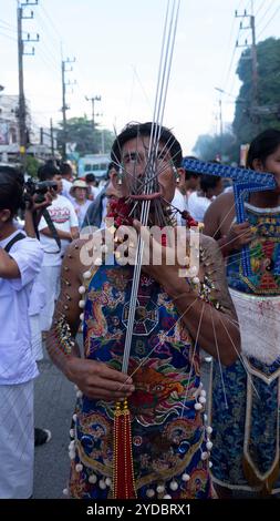 Un devoto cammina in processione dopo essere stato trafitto al Santuario Baan Tha Rua durante l'annuale Festival vegetariano nella città di Phuket. Il Festival ha generato 15 miliardi di Baht thailandesi nell'economia locale con oltre 400.000 visitatori. Foto Stock