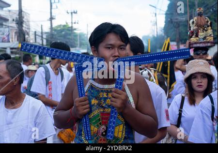 Un devoto cammina in processione dopo essere stato trafitto al Santuario Baan Tha Rua durante l'annuale Festival vegetariano nella città di Phuket. Il Festival ha generato 15 miliardi di Baht thailandesi nell'economia locale con oltre 400.000 visitatori. Foto Stock