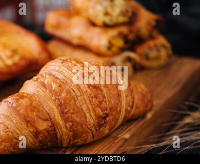 Croissant e panini freschi su tavola di legno Foto Stock
