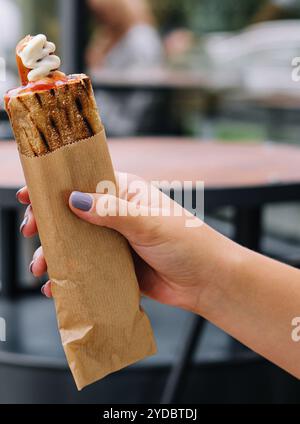 Hot dog francesi in mano alla donna Foto Stock