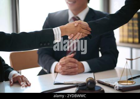 Consulente legale che stringe la mano con il cliente firma il contratto. nello studio legale. Stretta di mano per una riunione d'affari. Â Foto Stock