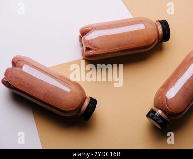 Frullati al cioccolato in bottiglie su sfondo marrone Foto Stock