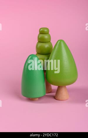 Modello in legno di un albero con corona verde e tronco su sfondo rosa Foto Stock