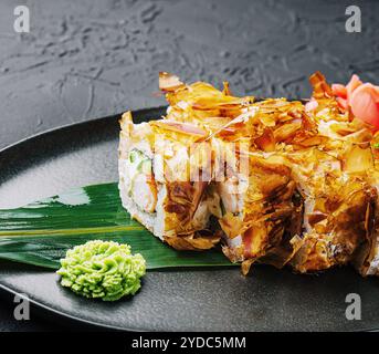 Panino di sushi bonito su un piatto scuro Foto Stock